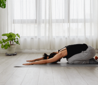 Rapariga a fazer yoga em casa 