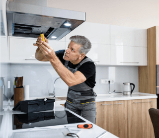 Senhor a arranjar um exaustor da cozinha 
