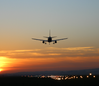Avião a sobrevoar o pôr do sol