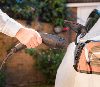 mão a colocar carregador elétrico