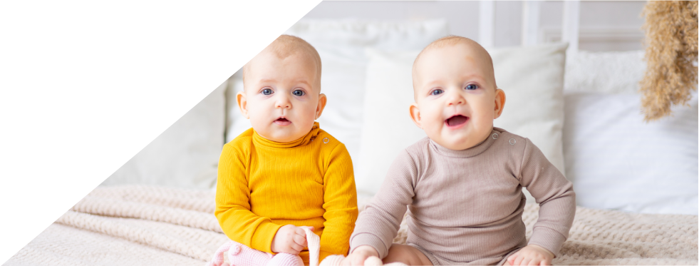 dois bebés sentados na cama