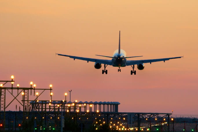 Avião a levantar voo ao pôr do sol