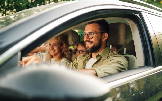 Família feliz dentro de um carro prontos para viajar