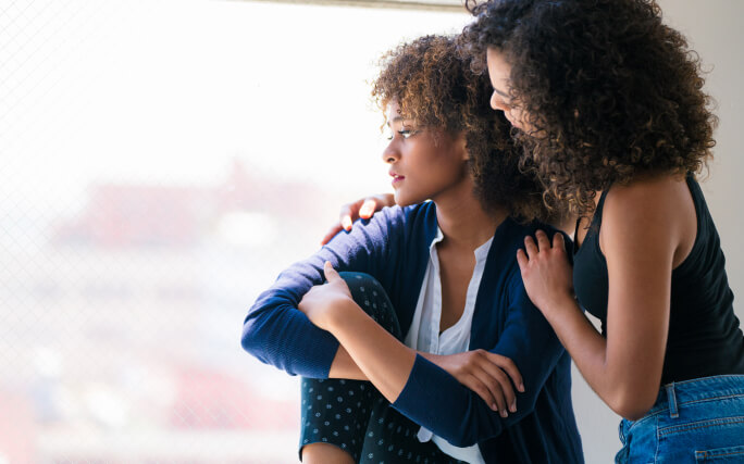 Uma mulher dá apoio a amigo de luto.