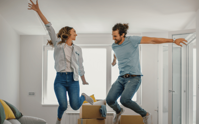 Casal de jovens a festejar depois de comprar a primeira casa.