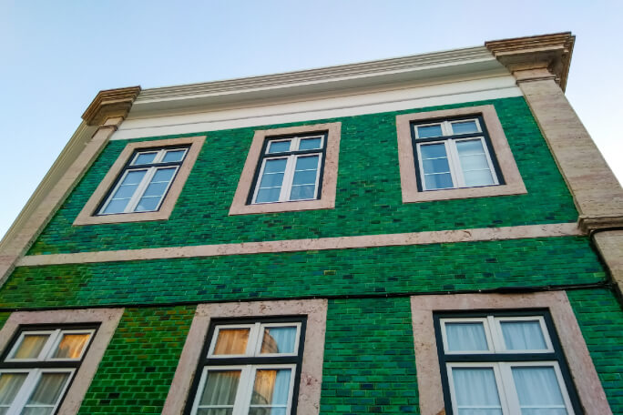 Parte de cima da fachada de um edifício restaurado em Lisboa