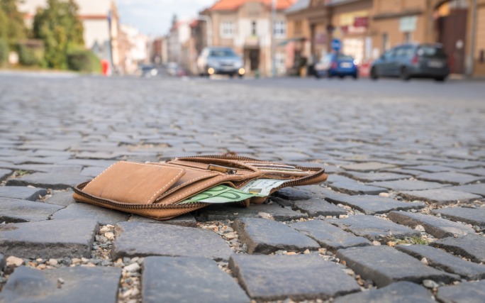Carteira aberta no chão depois de roubo de documentos.