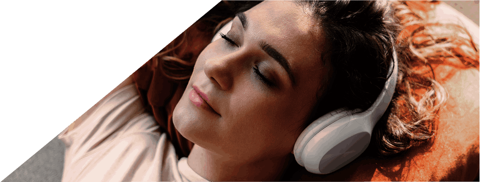 Mulher relaxa de olhos fechados enquanto ouve música com auscultadores.