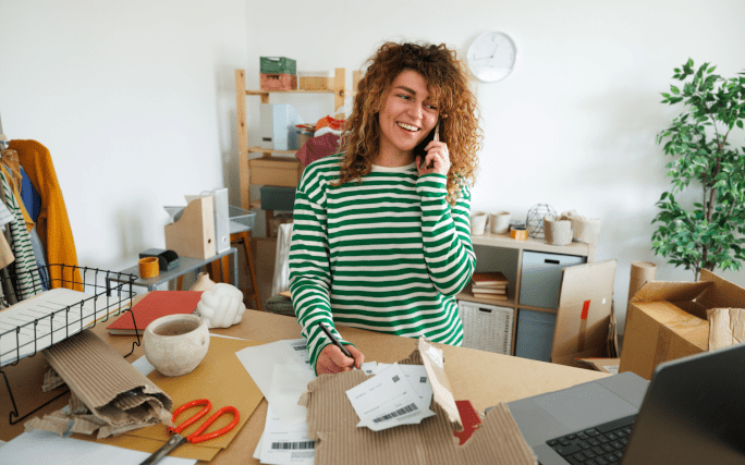 rapariga feliz a falar ao telefone em casa