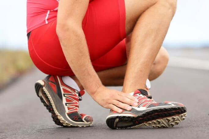 Corredor com lesão no tornozelo aperta o pé