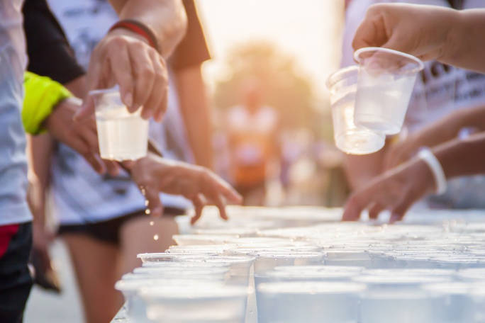 Grupo de atletas de corrida a pegar em copos de água