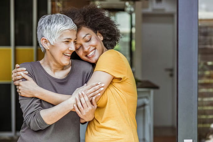 Rapariga jovem a abraçar mulher mais velha