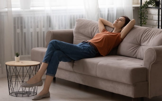 Mulher a descansar no sofá da sala