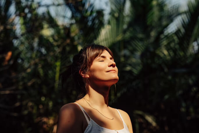 Jovem mulher faz respirações profundas para lidar com o stress.