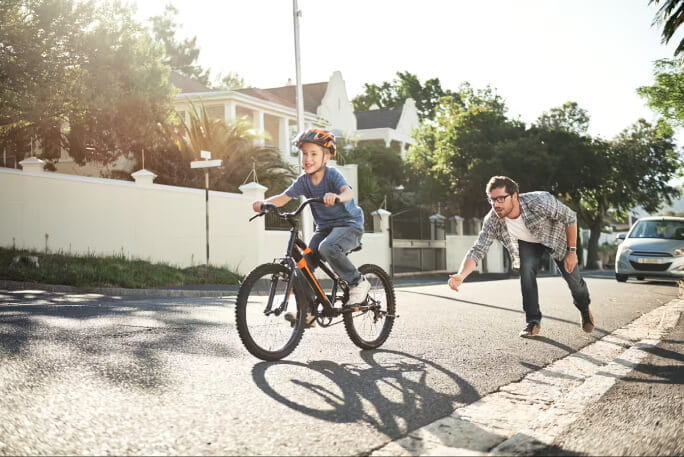 Pai ensina o filho a andar de bicicleta