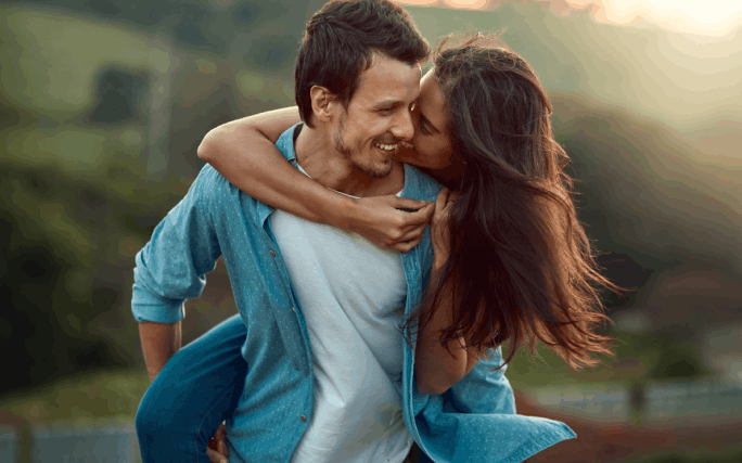 Rapariga às cavalitas de um rapaz, tranquilos por terem feito um seguro para jovens.