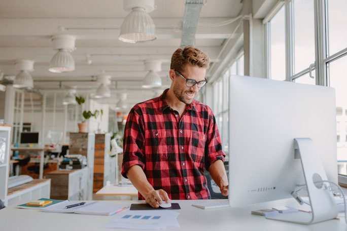 homem em pé ao computador